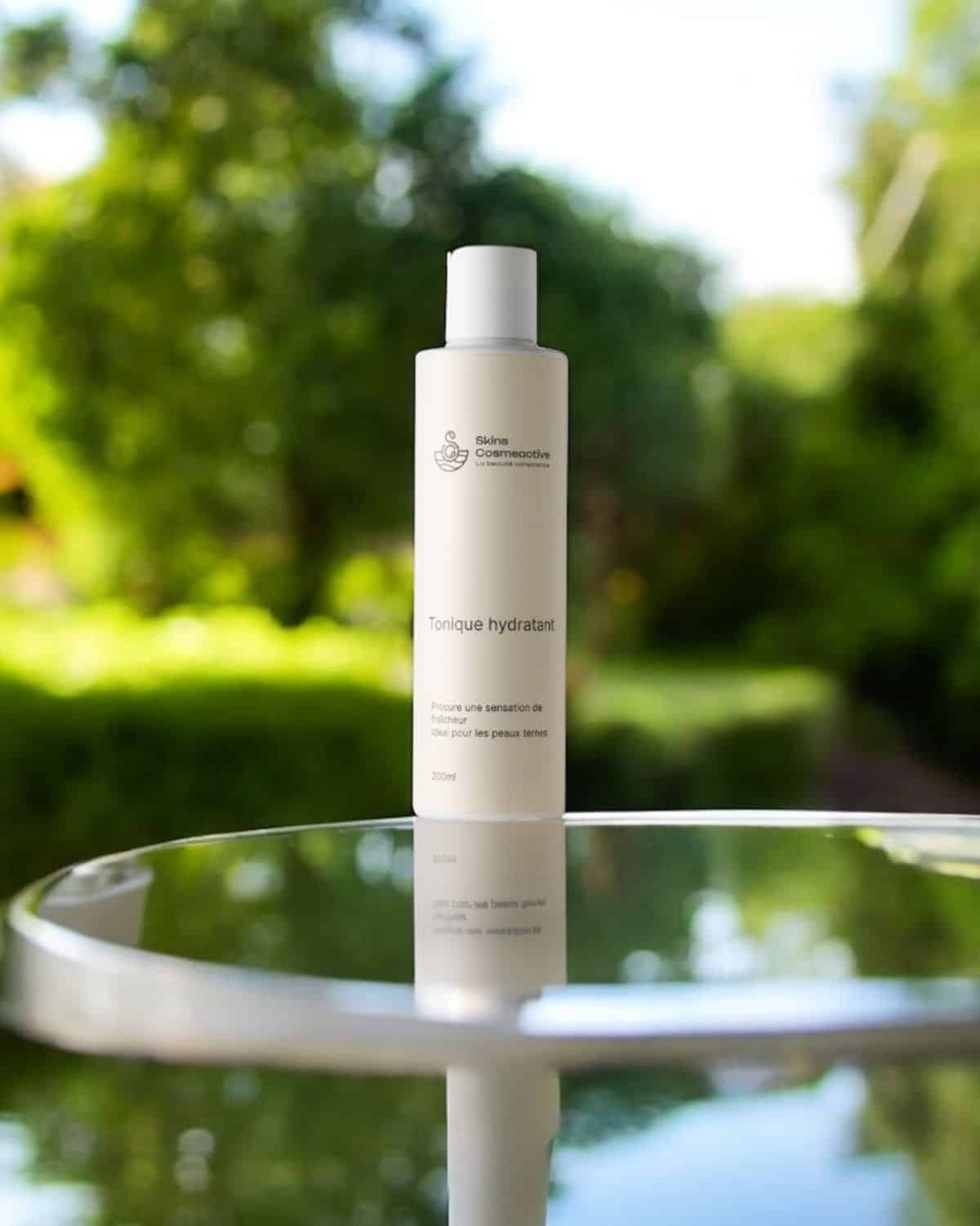 lotion tonique hydratante skinscosmeactive, flacon  blanc  sur fond naturel, soin visage  pour tout type de peaux y compris les peaux noires, mates et métissées